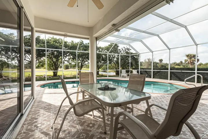 Outdoor pool featuring a lanai, a patio, a sunroom, and outdoor dining area