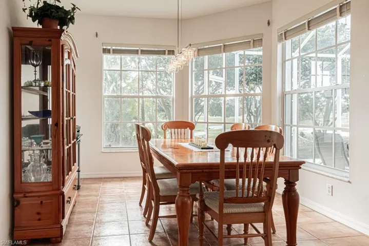 Dining space with light tile patterned floors, healthy amount of natural light, and a chandelier