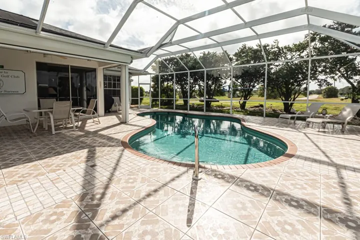 Outdoor pool with a patio, a sunroom, and glass enclosure