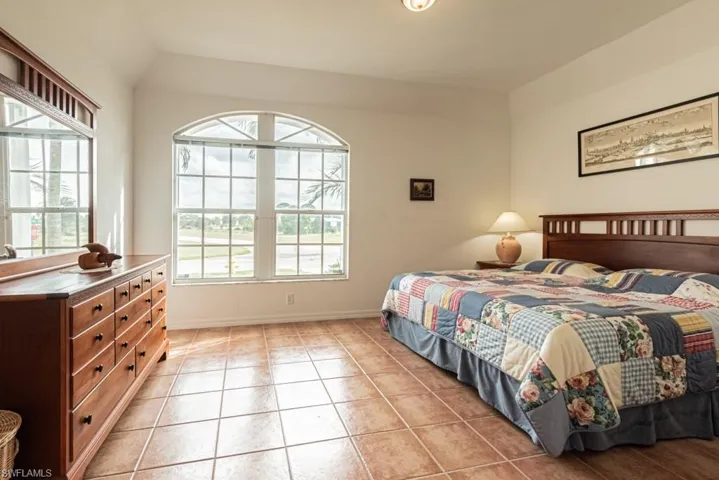 Bedroom featuring light tile patterned flooring and vaulted ceiling