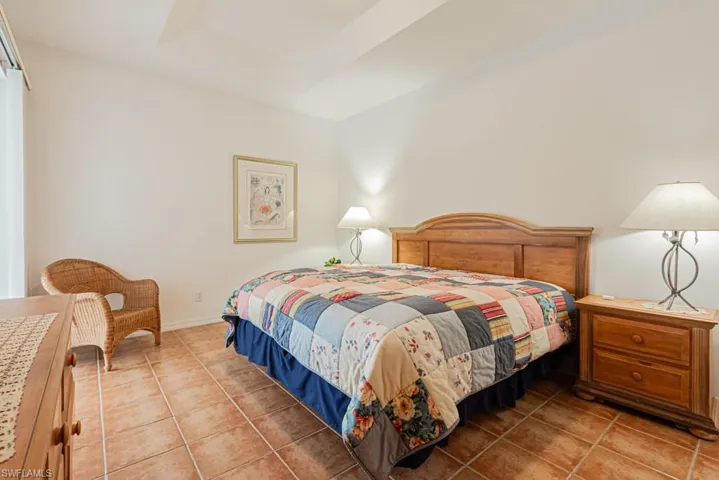 Bedroom featuring light tile patterned floors and a raised ceiling