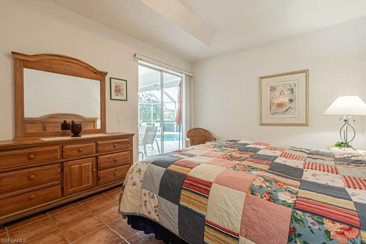 Bedroom with access to outside, light tile patterned flooring, and a raised ceiling
