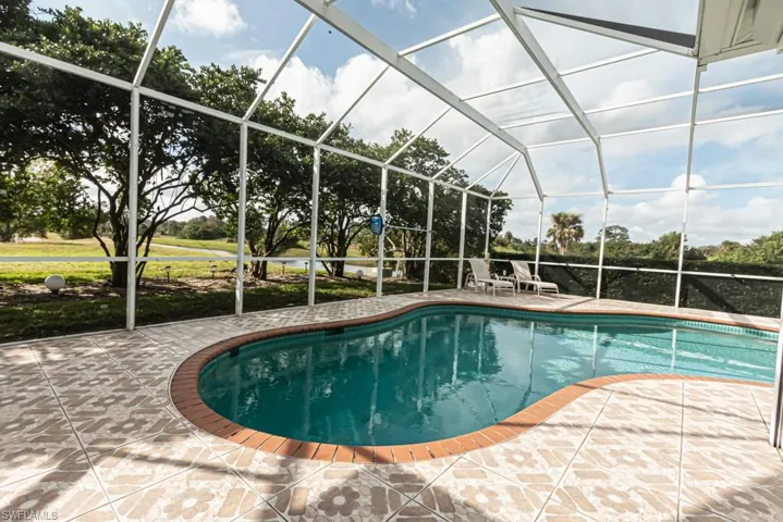 Swimming pool featuring glass enclosure, a sunroom, and a patio area