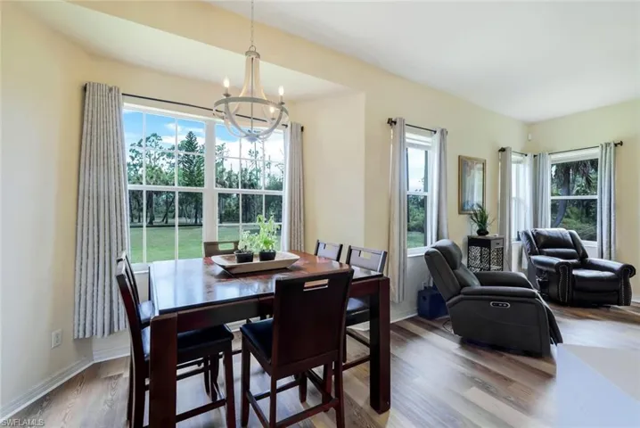 Dining space with a notable chandelier, hardwood / wood-style flooring, and a wealth of natural light