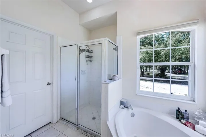 Bathroom with tile flooring and shower with separate bathtub