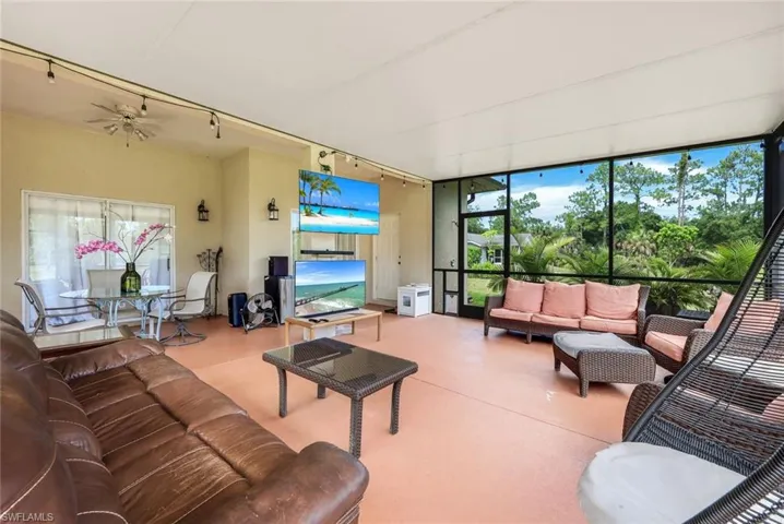 Living room featuring a wealth of natural light, ceiling fan, and rail lighting