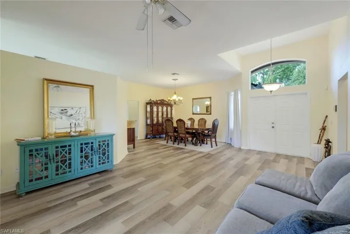 Living room featuring wood-type flooring and ceiling fan with notable chandelier