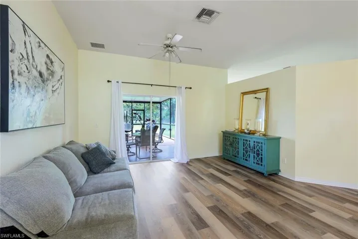 Living room with ceiling fan and hardwood / wood-style flooring
