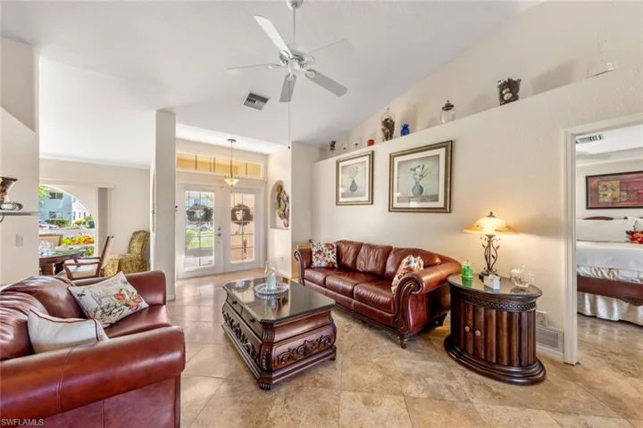 Living room featuring ceiling fan, french doors, and high vaulted ceiling