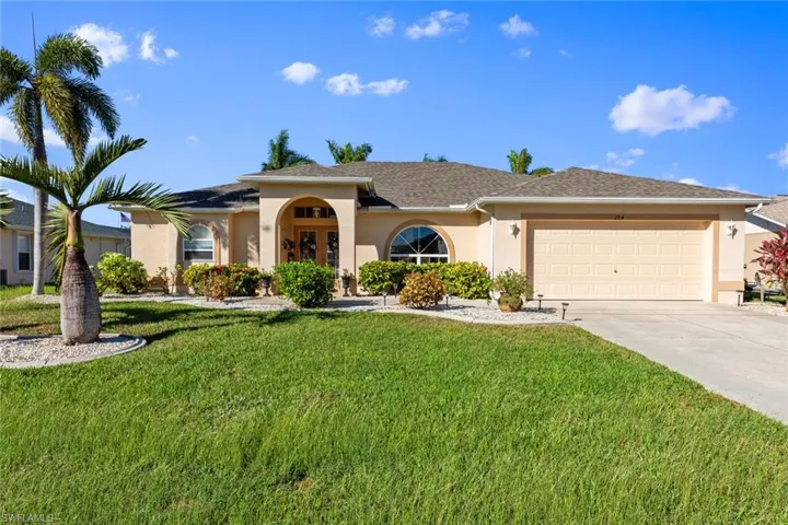 View of front of home featuring a front lawn and a garage