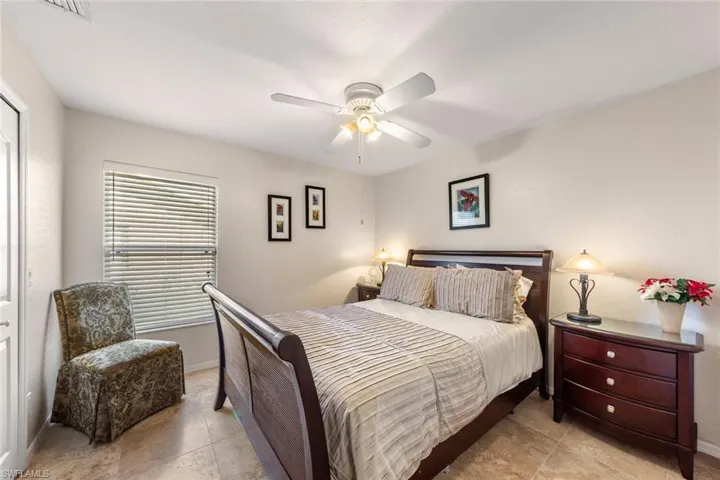 Tiled bedroom featuring ceiling fan