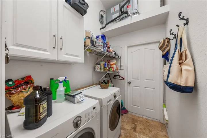 Clothes washing area with washer and clothes dryer and cabinets