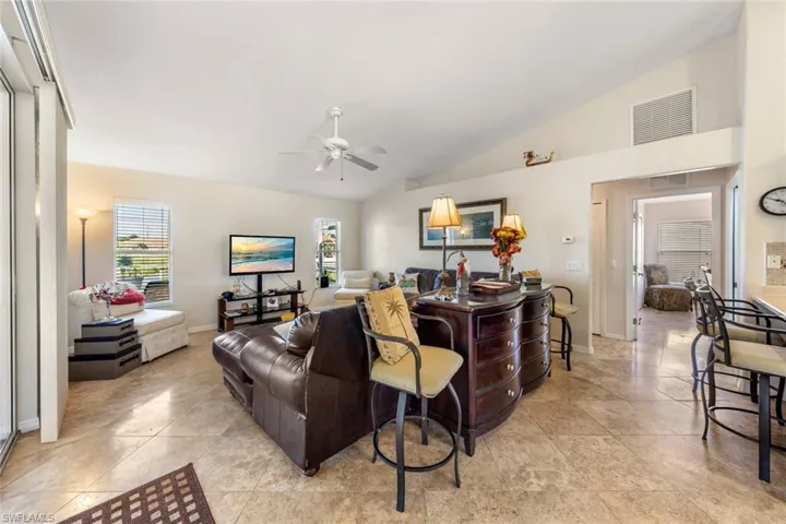 Living room with ceiling fan and lofted ceiling