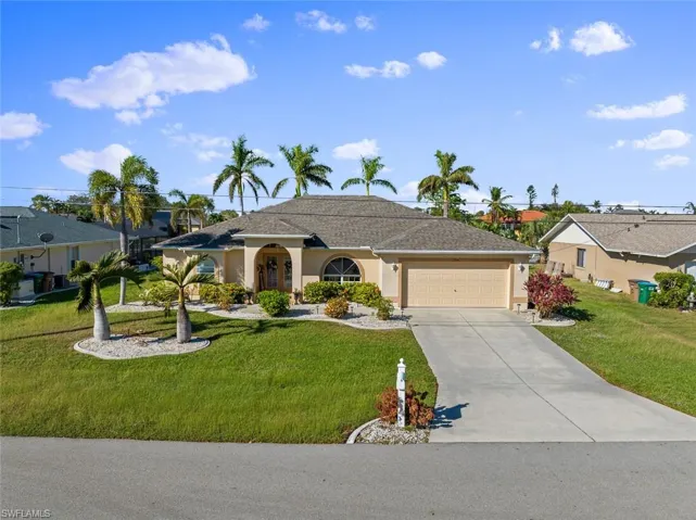 Ranch-style home with a front yard and a garage