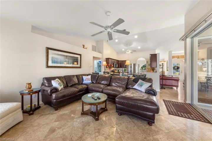 Living room featuring ceiling fan and lofted ceiling