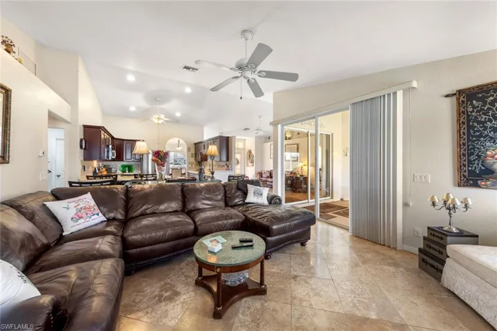 Living room featuring ceiling fan and lofted ceiling