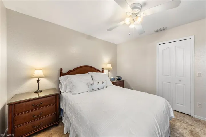 Bedroom featuring ceiling fan, light colored carpet, and a closet