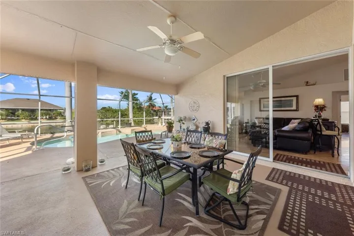 Sunroom featuring ceiling fan, a pool, and vaulted ceiling