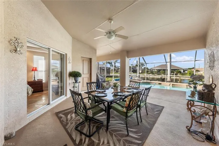 Sunroom / solarium with ceiling fan, a water view, and vaulted ceiling