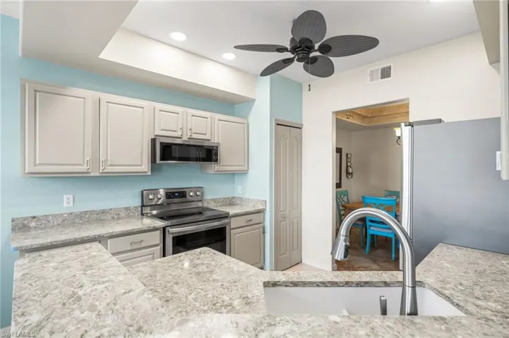 Kitchen with appliances with stainless steel finishes, light cabinetry.
