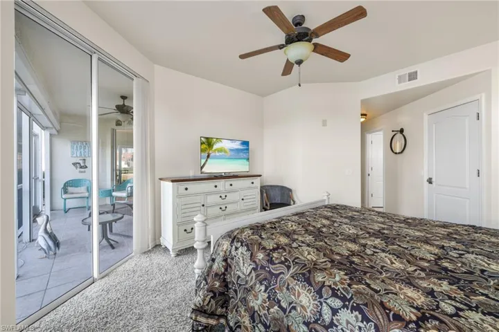 Bedroom with ceiling fan, light colored carpet, and access to exterior
