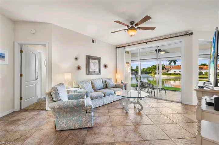 Living room featuring ceiling fan and a water view
