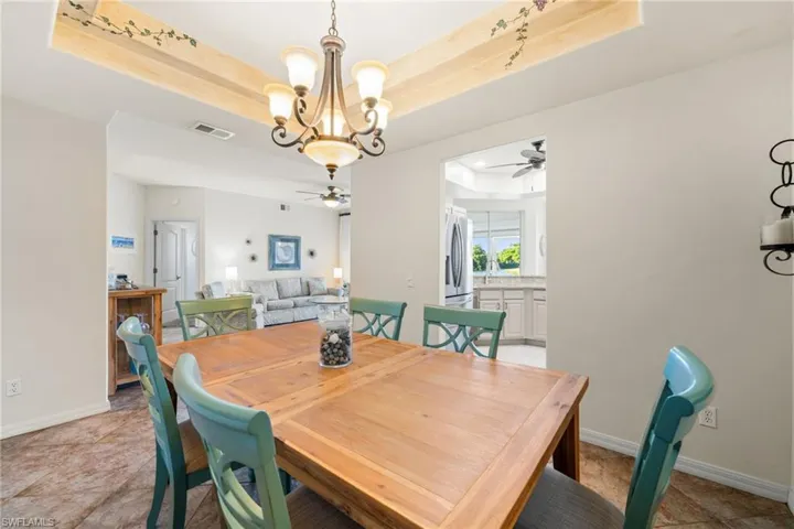 Formal dining space with notable chandelier, double tray ceiling.