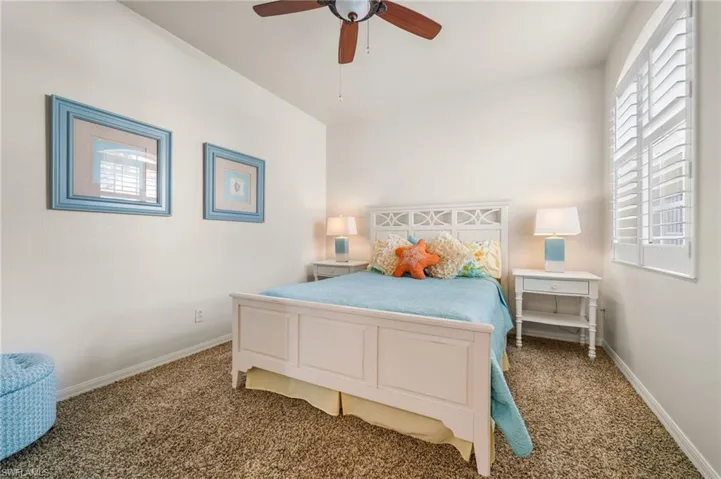 2nd bedroom featuring a queen bed, ceiling fan and carpet floors.