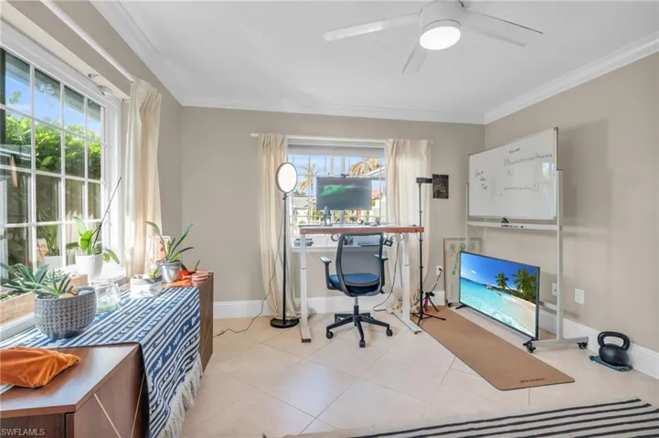 Home office with ceiling fan, plenty of natural light, and ornamental molding