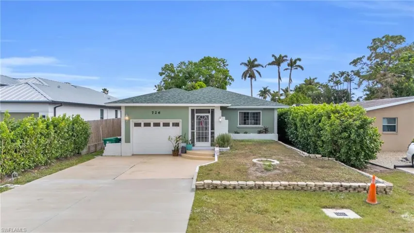Ranch-style home featuring a garage and a front yard