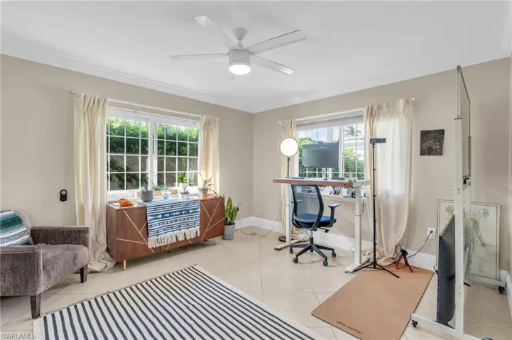 Office with ceiling fan, light tile patterned floors, and a wealth of natural light