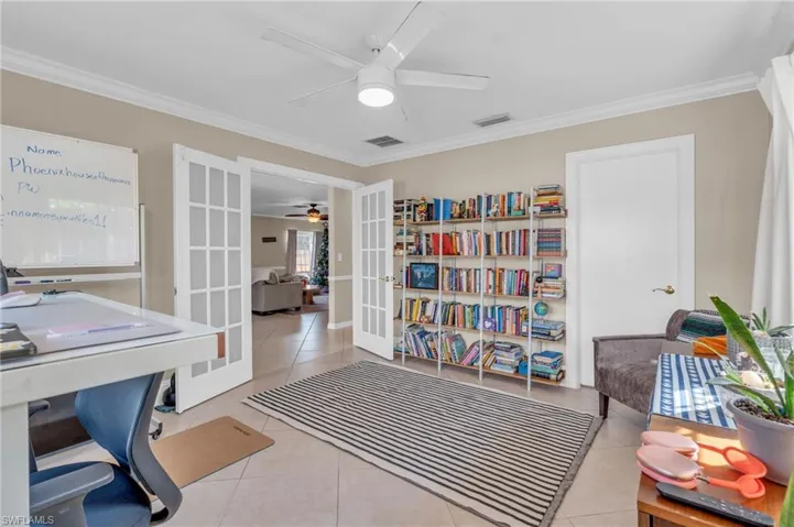 Tiled office space with ceiling fan, french doors, and ornamental molding