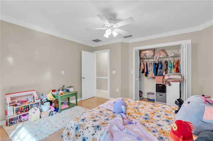 Bedroom with a closet, crown molding, ceiling fan, and light hardwood / wood-style floors