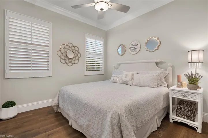 Bedroom with ceiling fan, dark hardwood / wood-style flooring, and crown molding