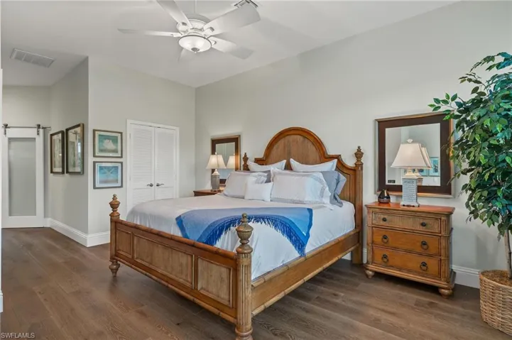 Bedroom with ceiling fan, a closet, and dark hardwood / wood-style flooring