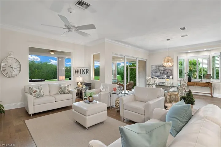 Living room featuring ceiling fan, a wealth of natural light, dark hardwood / wood-style floors, and crown molding