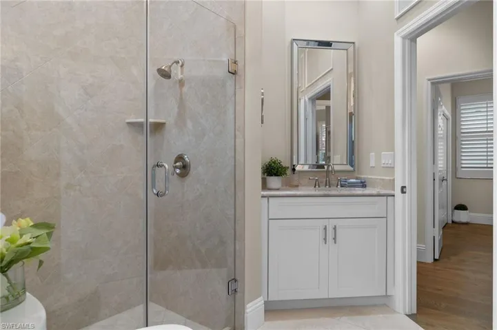 Bathroom featuring vanity, hardwood / wood-style flooring, and walk in shower