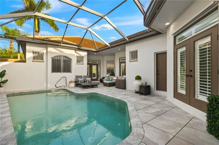 View of pool with a lanai, an outdoor hangout area, and a patio