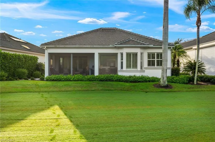 Back of house featuring a yard and a sunroom