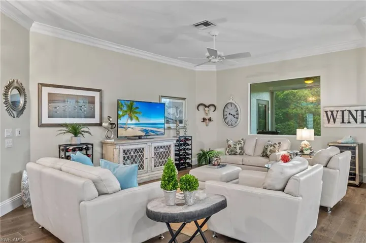 Living room with crown molding, hardwood / wood-style floors, and ceiling fan