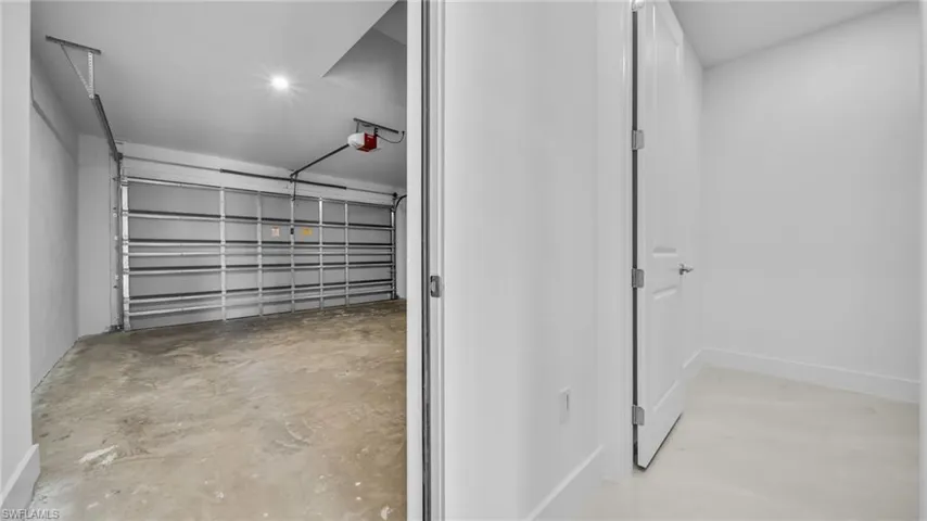 Garage featuring a garage door opener and recessed lighting