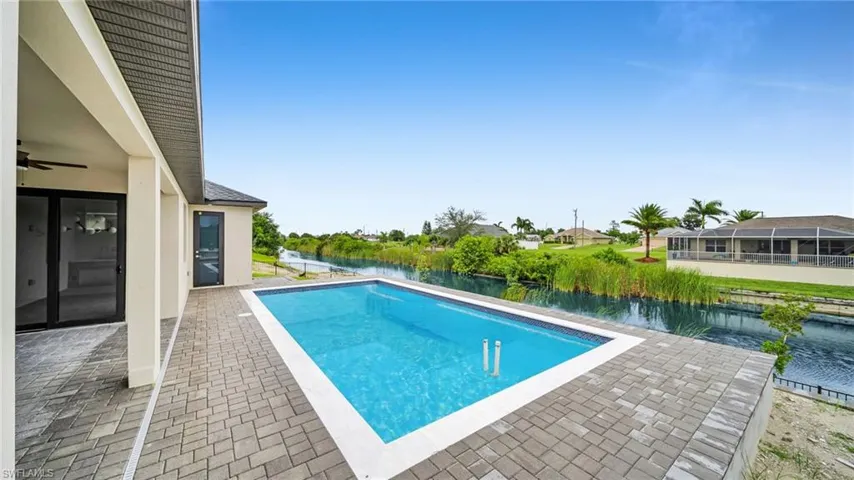 Outdoor pool featuring a patio area and a water view