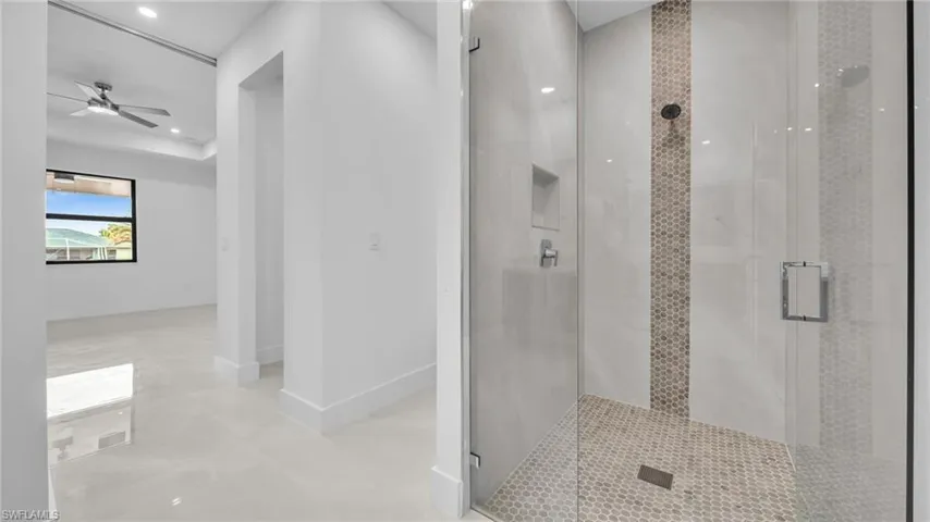 Bathroom with a stall shower, recessed lighting, and a ceiling fan