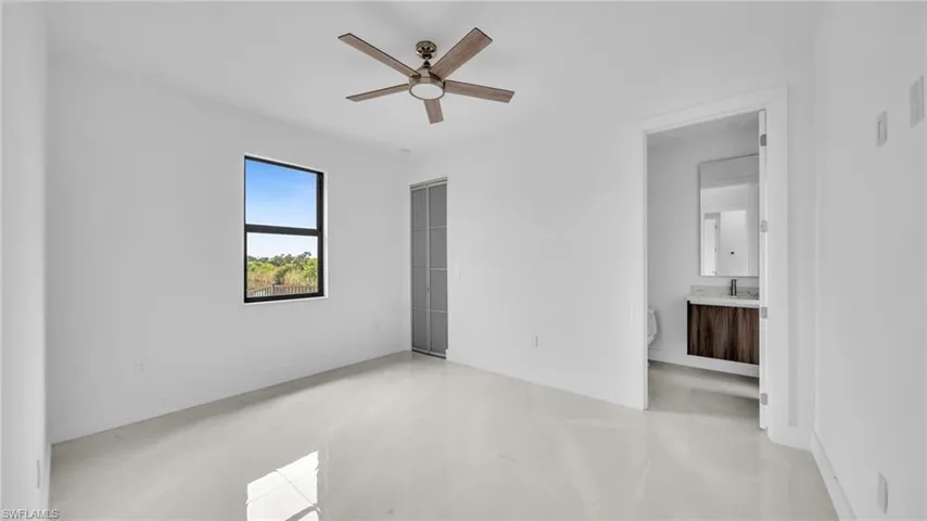 Unfurnished bedroom featuring ensuite bath and ceiling fan
