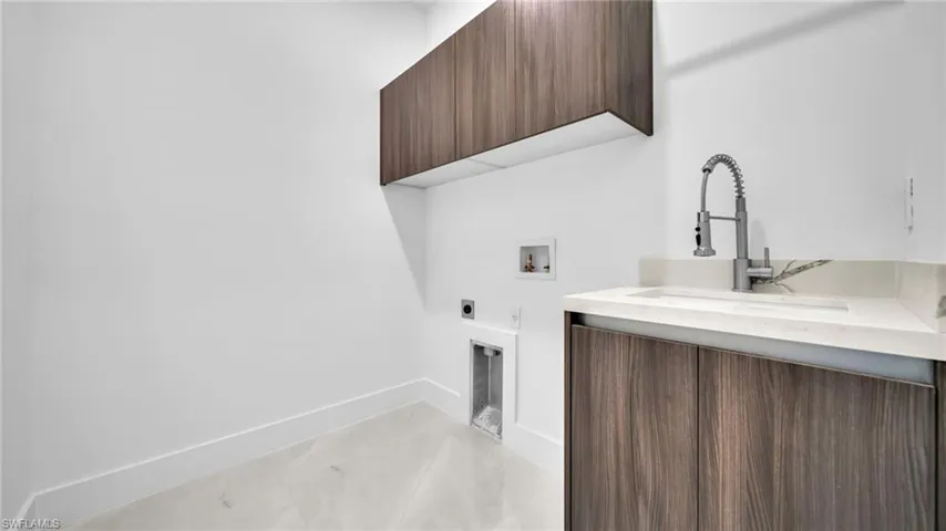 Laundry area featuring hookup for an electric dryer, washer hookup, and cabinet space