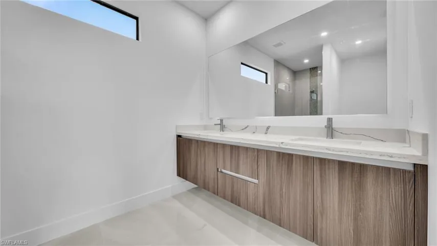 Full bathroom featuring a stall shower and double vanity