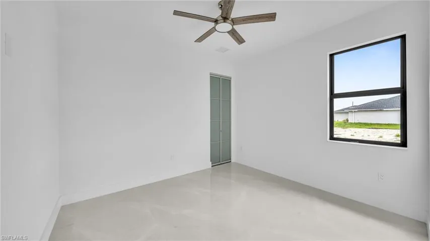 Unfurnished room featuring a ceiling fan and finished concrete flooring