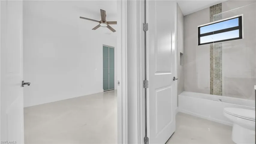 Bathroom featuring tub / shower combination and ceiling fan