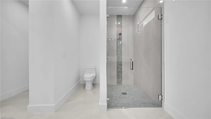 Full bath featuring toilet and a shower stall