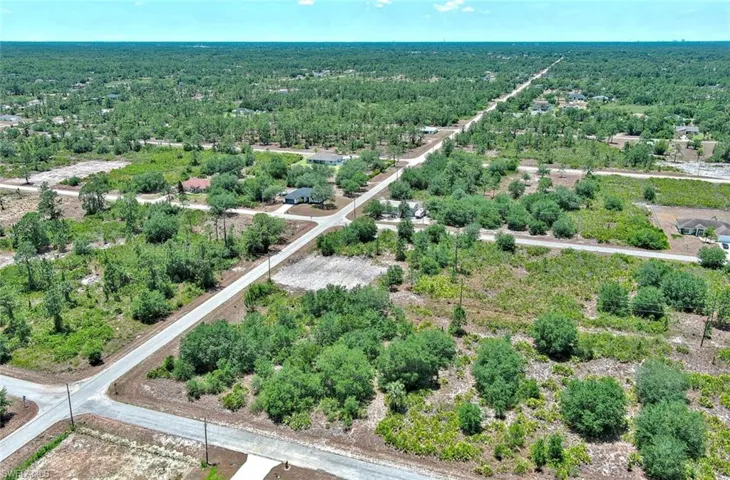 View of property location with a heavily wooded area